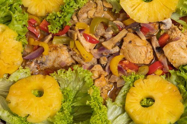 Ananász csirkehússal a zöldségekben. Kulináris háttér szelektív fókusszal és homályos háttérrel. - Fotó, kép