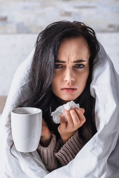 malade jeune femme brune avec tissu et boisson chaude au lit - Photo, image