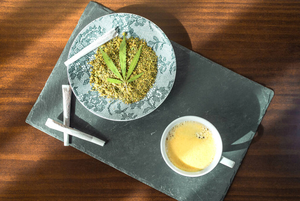 Vista superior da bandeja de pedra com café fresco, maconha e um prato cheio de cannabis. Pequeno-almoço ou lanche perfeito. - Foto, Imagem