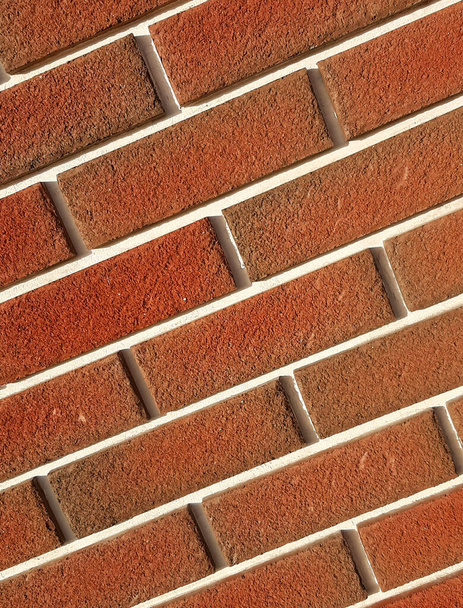 Beveled corner wall built of red brick with white seams. Textured brickwork - Photo, Image