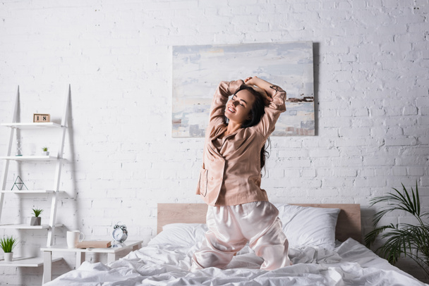 lächelnde junge brünette Frau morgens im Bett - Foto, Bild
