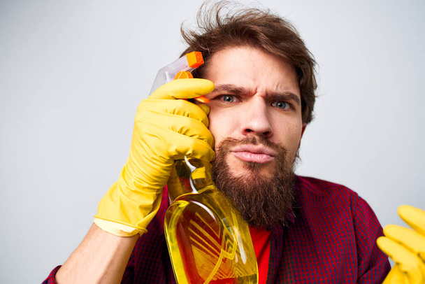 Man in yellow gloves detergent cleaning professional cropped view of housework lifestyle - 写真・画像