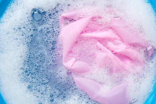 Kolor ubrania moczyć w proszku rozpuszczania wody detergent. Koncepcja pralni - Zdjęcie, obraz