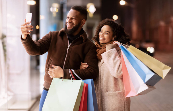 Feliz casal afro tirar selfie depois de fazer compras na cidade - Foto, Imagem