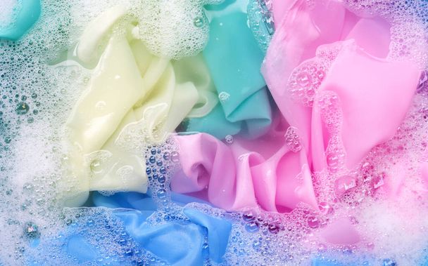 Color clothes soak in powder detergent water dissolution. Laundry concept - Fotó, kép