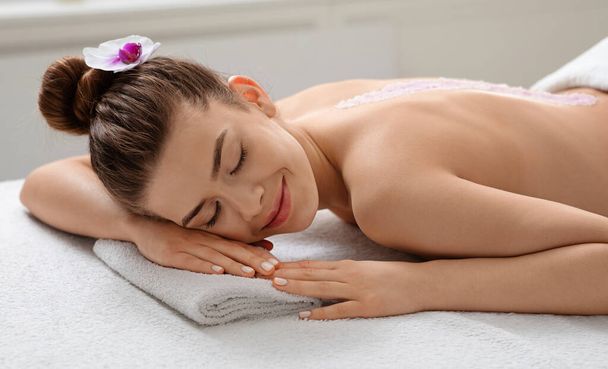 Крупним планом спокійна молода жінка насолоджується морським соляним масажем
 - Фото, зображення