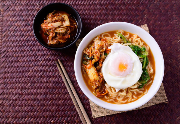Koreai étel, fűszeres tészta leves kimchivel és tojással egy tálban, Felülnézet - Fotó, kép