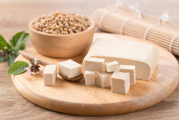 Cube de tofu frais et graines de soja sur planche à découper en bois préparer pour la cuisson, Aliments végétaliens asiatiques - Photo, image