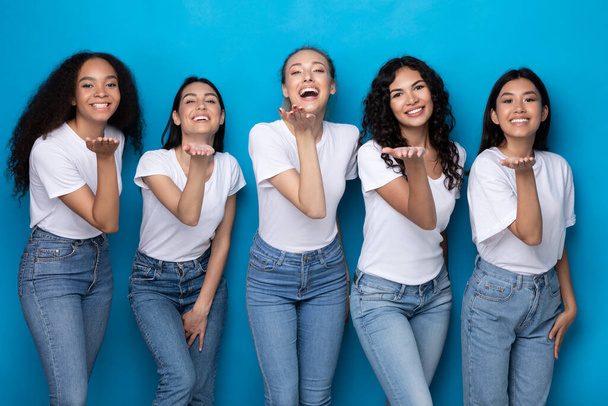 Cinco senhoras multiculturais alegres enviando beijos de ar sobre fundo azul - Foto, Imagem