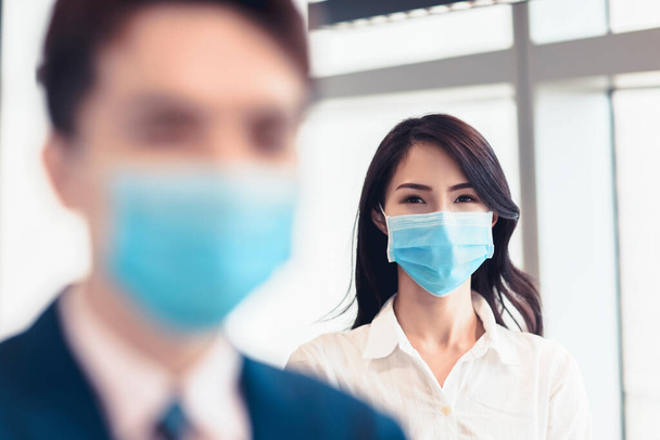 Hombre y mujer de negocios que usan mascarilla médica mientras trabajan en la oficina - Foto, imagen