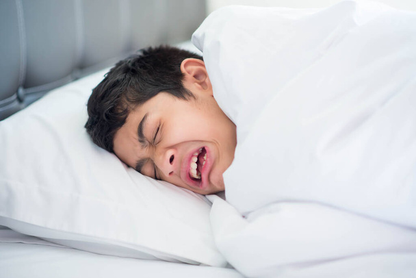Adolescente menino dormindo na cama com cobertor capa feliz sorriso rosto - Foto, Imagem