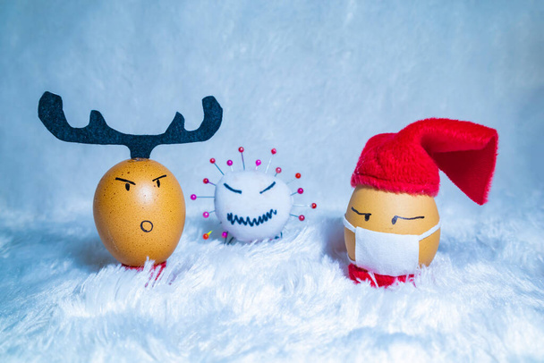 Roztomilé malované vejce s panenkou viru korony na oslavu Vánoc v dobách covid pandemie. Zábavné vnitřní aktivity s dětmi. - Fotografie, Obrázek