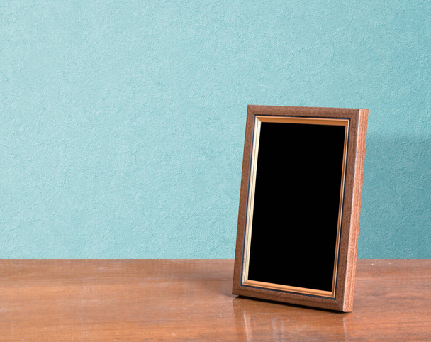 marco de fotos de madera en la mesa, pared azul - Foto, imagen