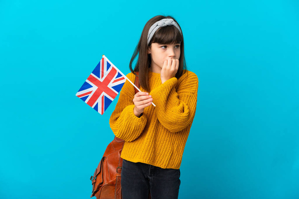 Malá dívka studuje angličtinu izolované na modrém pozadí s pochybnostmi - Fotografie, Obrázek