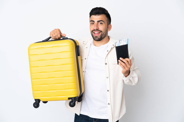 Hombre caucásico sobre fondo blanco aislado en vacaciones con maleta y pasaporte - Foto, Imagen
