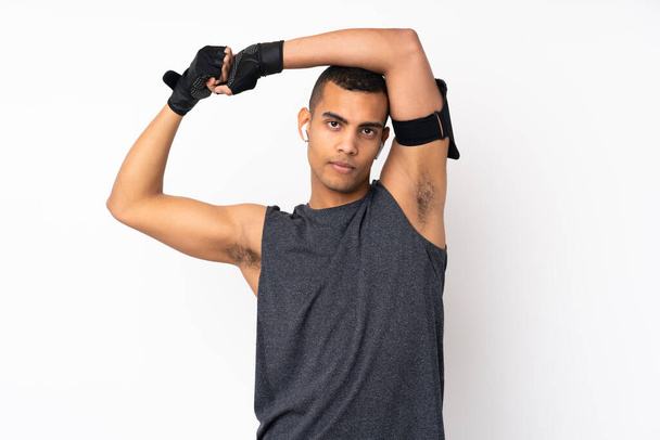 Young African American sport man over isolated white background stretching arm - Zdjęcie, obraz