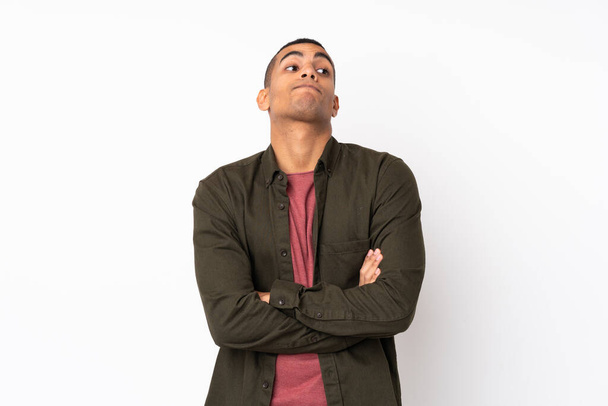 Young African American man over isolated white background making doubts gesture while lifting the shoulders - Foto, afbeelding