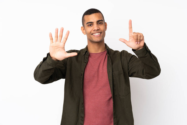 Junger Afroamerikaner vor isoliertem weißen Hintergrund, der mit den Fingern sieben zählt - Foto, Bild