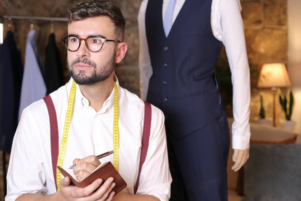 retrato de diseñador de moda joven guapo en su taller - Foto, imagen