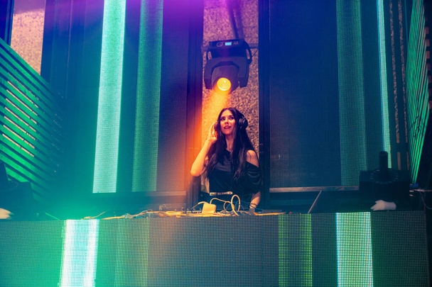 DJ на сцене в ночном клубе диско микшируя техно-музыку - Фото, изображение