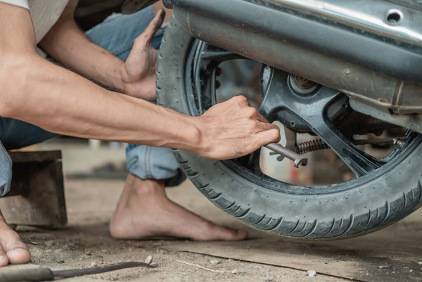 view side of tire repairman removing the inner tires of a motorbike using a tire scraping tool - Foto, Imagem