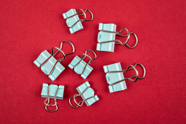 Binder paper clips on a red background. Office supplies - 写真・画像