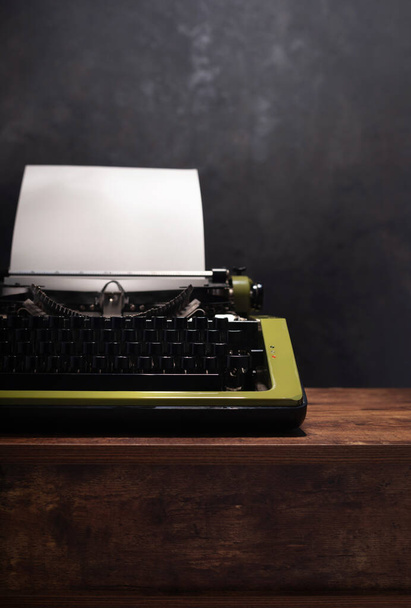 vintage typewriter at wooden table near wall background surface, abstract retro writer concept - Foto, Imagen
