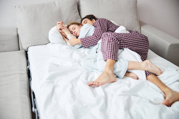 Счастливая пара в любви обнимается и спит в постели - Фото, изображение