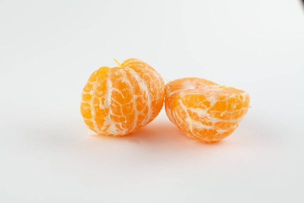 a beautiful ripe peeled tangerine on a white background - Фото, изображение