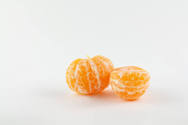 a beautiful ripe peeled tangerine on a white background - Photo, Image