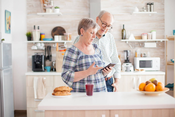 Old couple using smartphone - Foto, afbeelding