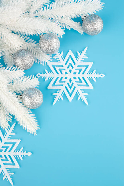 Vánoční dekorace s šedými kuličkami, sněhové vločky a jedle-strom bílá větev na modrém pozadí. - Fotografie, Obrázek