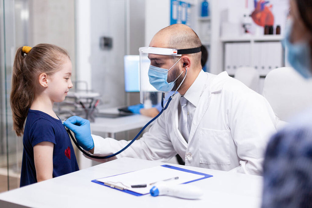 Pediatrician listening heart - Фото, изображение