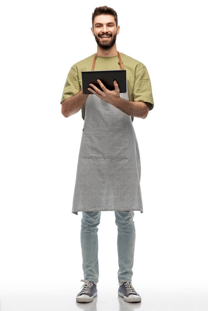 smiling waiter in apron with tablet pc computer - Fotoğraf, Görsel