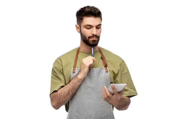 waiter in apron taking notes to notepad - Foto, immagini