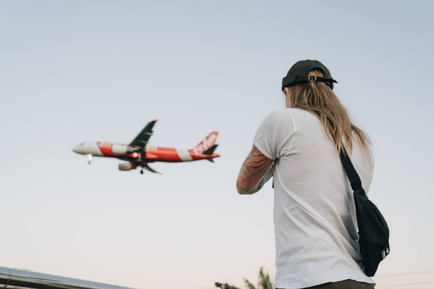 Blonde man shooting airplane flying in the sky - Foto, Bild