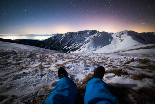 Καθισμένος και χαλαρός κάτω από τα αστέρια, χειμώνας στα βουνά - Φωτογραφία, εικόνα