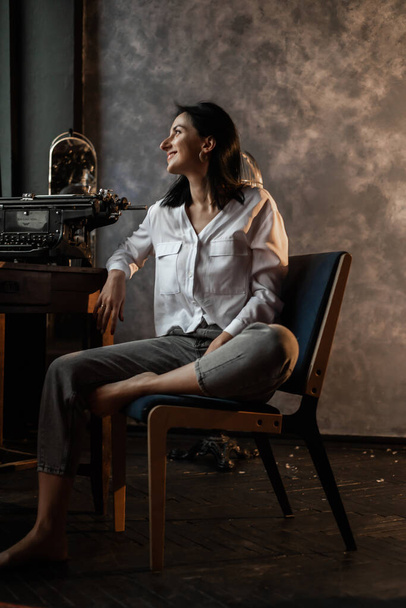Woman at home sitting on a chair wearing white shirt - Valokuva, kuva