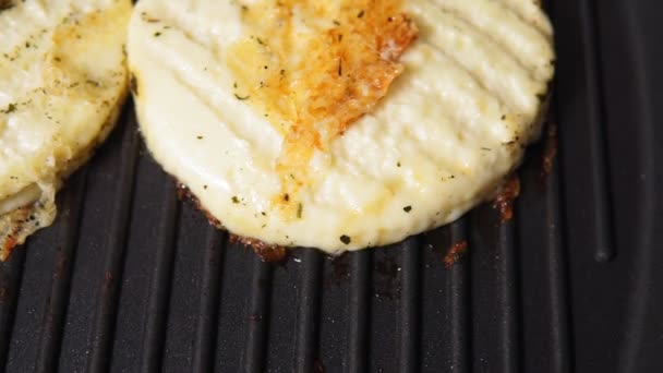 Grillezett haloumi sajt fűszerekkel egy grill serpenyőn. szelektív fókusz - Felvétel, videó