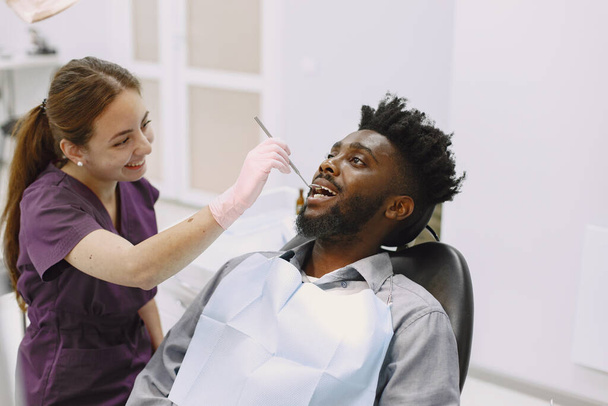 Αφρικανός ασθενής οδοντιατρικής κάθεται σε οδοντιατρική καρέκλα - Φωτογραφία, εικόνα