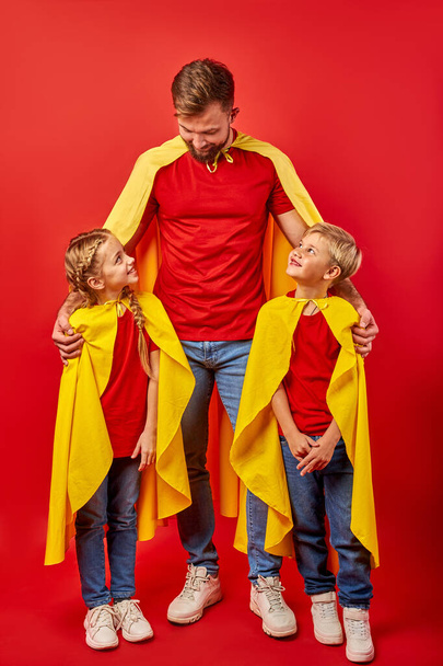 young handsome father in superhero costume is responsible for children - Fotoğraf, Görsel