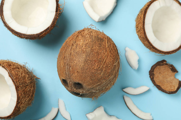 Čerstvé chutné kokosové ořechy na modrém pozadí, horní pohled - Fotografie, Obrázek