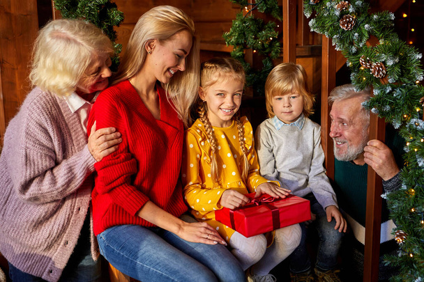 children get christmas gifts from mother and grandmother - Foto, Imagen