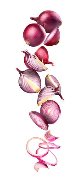 Chopped and whole onions in flight on a white background - Valokuva, kuva