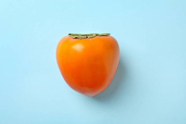 Fresh ripe persimmon on blue background, close up - Photo, Image