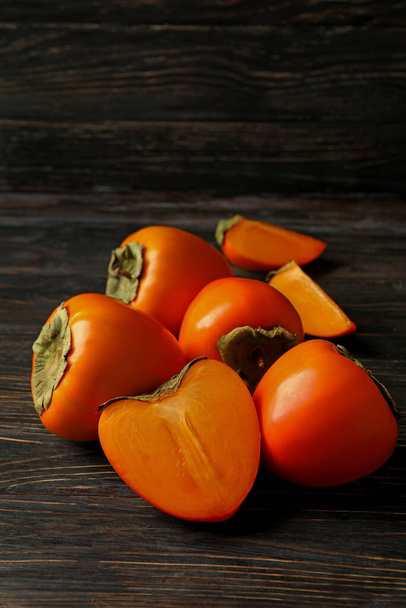 Fresh ripe persimmon on wooden background, space for text - Photo, Image