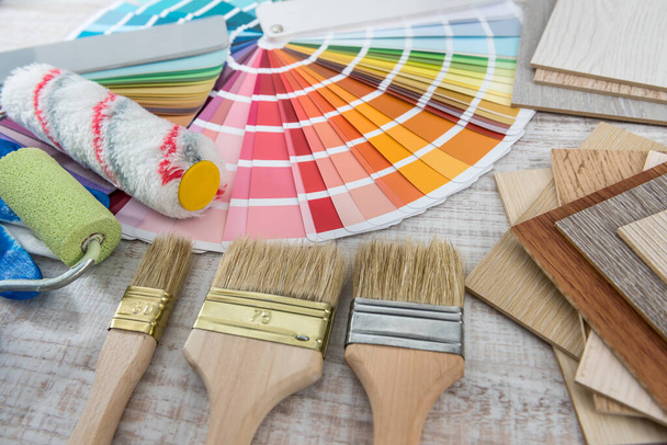 conjunto de pinceles de pintura bandeja de rodillos y paleta de papel de color sobre tabla de madera. Reparación casera  - Foto, imagen