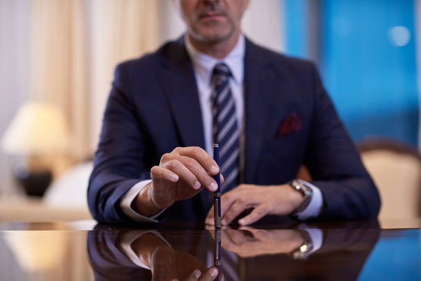 corporate businessman holding pen and gesturing with hands concpet of business deal - Photo, Image