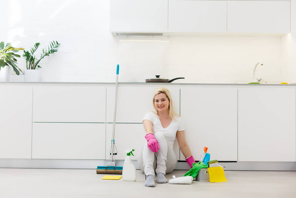 Молодая домохозяйка расслабляется после уборки, релаксация после уборки - Фото, изображение