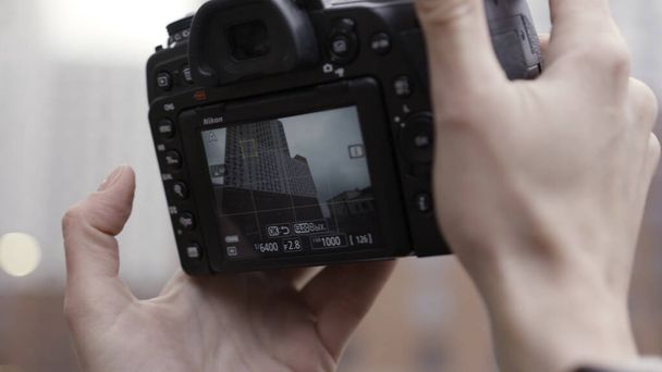新しい高層ビルの写真を撮るのに近い新しい場所を発見してください。行動だ。都市現代建築で写真を撮るプロのカメラと女性の手. - 写真・画像